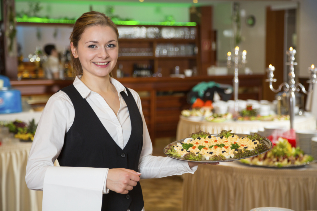 Catering service employee or waitress posing with a tray of appetizers