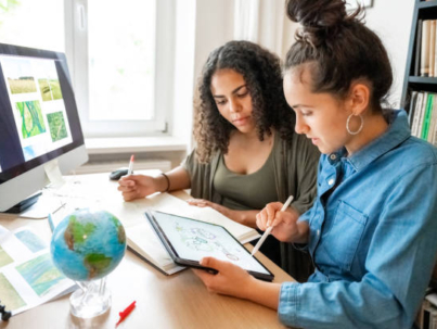 two young woman preparing together concepts for climate protection on desk indoors