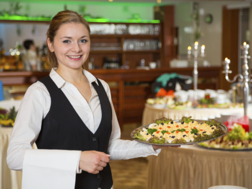 Catering service employee or waitress posing with a tray of appetizers